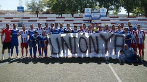 Jugadores de ambos equipos posan con una pancarta en un amistoso celebrado la temporada recién acabada
