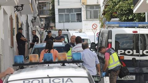 Agentes vigilan la puerta de la vivienda donde se hallaron los cadáveres