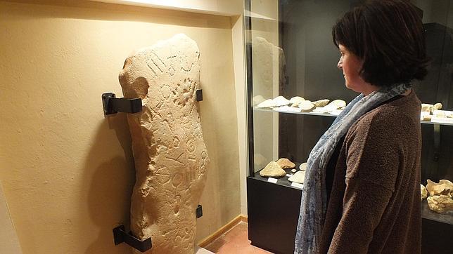 Una mujer contempla la estela ubicada en el Museo Arqueológico de Montoro