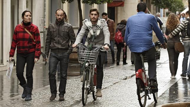 Varios ciclistas por una zona peatonal