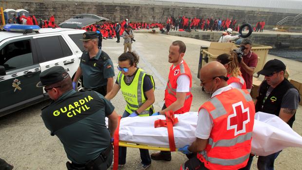 Efectivos de la Guardia Civil y Cruz Roja trasladan uno de los cuerpos rescatados en el mar