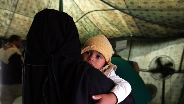 Una madre sostiene a su hijo enfermo de cólera en un hospital de campaña en Yemen