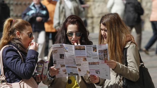 Tres turistas consultan un plano de la ciudad