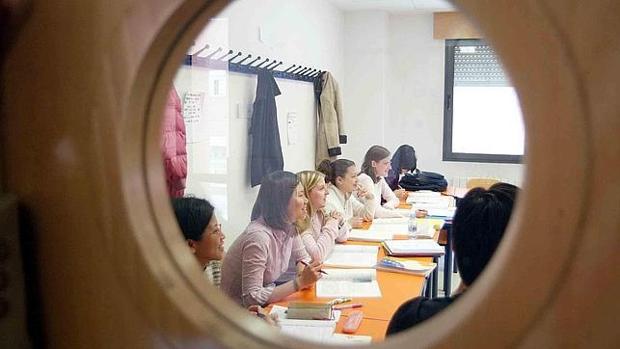 Varios alumnos atienden a la explicación de un profesor