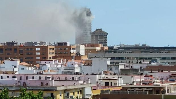 Vista parcial de la ciudad en la que se ve el edificio envuelto en una humareda