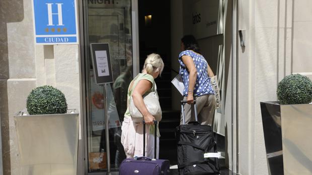 Una pareja de turistas acceden a un hotel de Málaga capital.