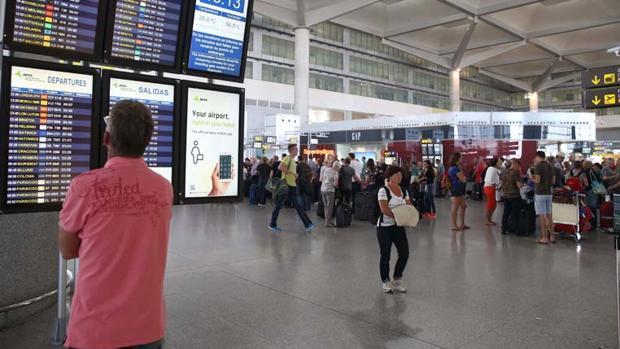 Un pasajero mira los vuelos en el aeropuerto de Málaga