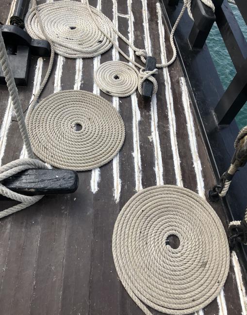 Los cabos, perfectamente adujados en la cubierta, en proceso de calafateado
