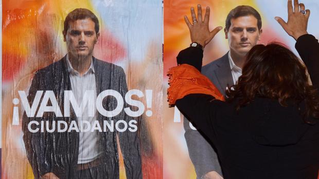 Una simpatizante de Ciudadanos pega carteles electorales en Valladolid