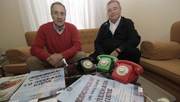 Manuel García Carretero, presidente del «teléfono de la esperanza» en Sevilla, junto a Antonio, voluntario, y los telefónos rojo, negro y verde con los que se empezó la actividad hace casi medio siglo