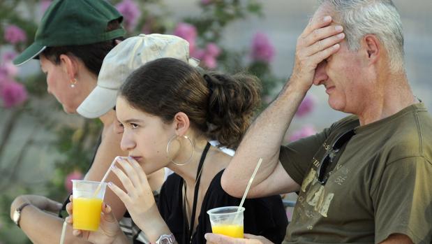 Turistas en la Plaza de España refrescándose con una bebida fría