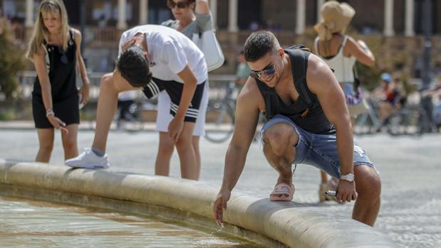 Turistas refrescándose en la fuente de la Plaza de España
